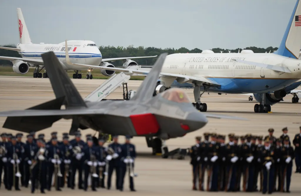 Air China airplane carrying Chinese President Xi Jinping and his wife Peng Liyuan arriving at Joint Base Andrews, with an Air Force One plane and military personnel present.