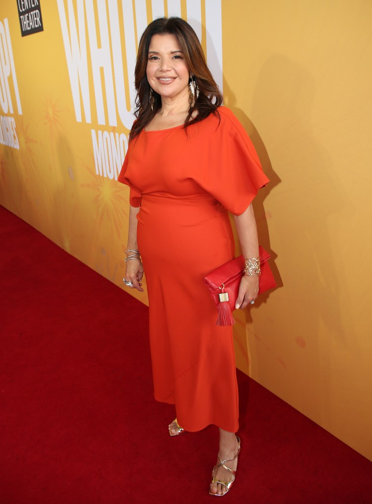 Ana Navarro on a red carpet in an orange dress at