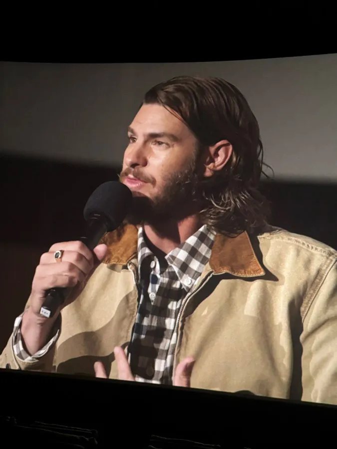 Andrew Garfield speaking into a microphone.