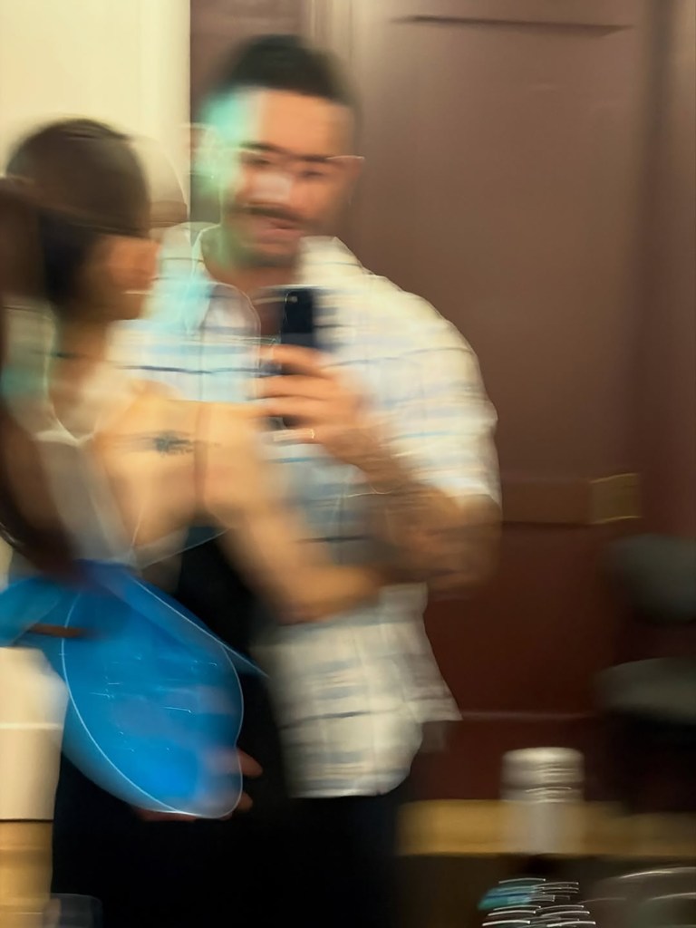 A blurry photo shows Ariana Grande and Ricky Alvarez posing for a selfie.