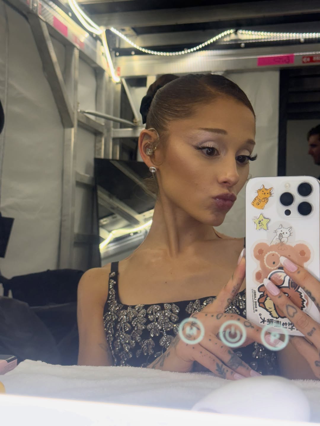 Ariana Grande taking a selfie while puckering her lips.