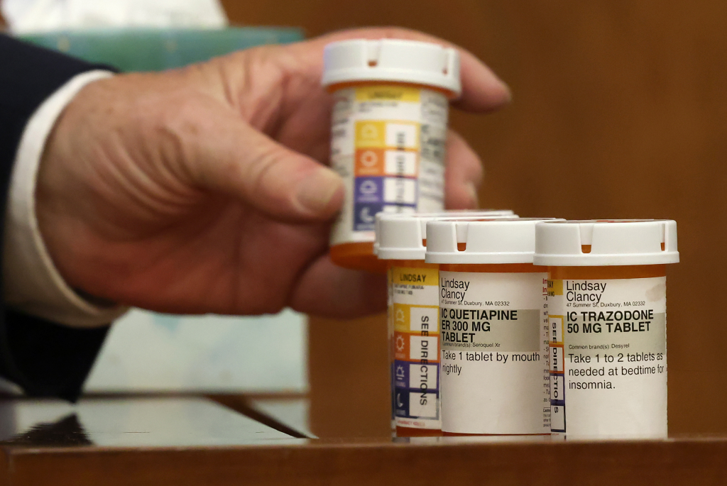 Attorney Kevin Reddington holds up prescription pill bottles for Lindsay Clancy during her murder trial.