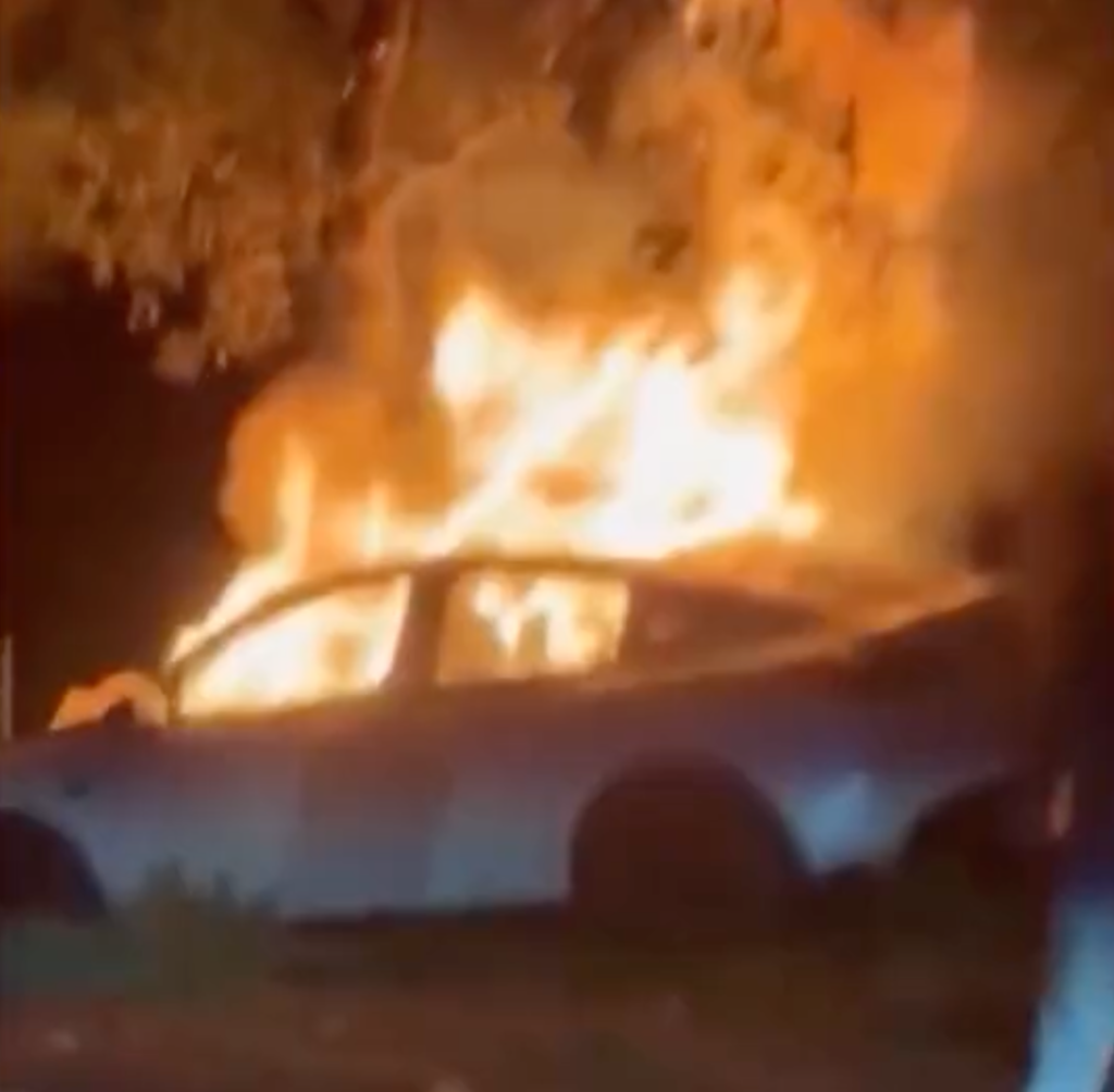 A Tesla engulfed in flames after crashing into a tree.