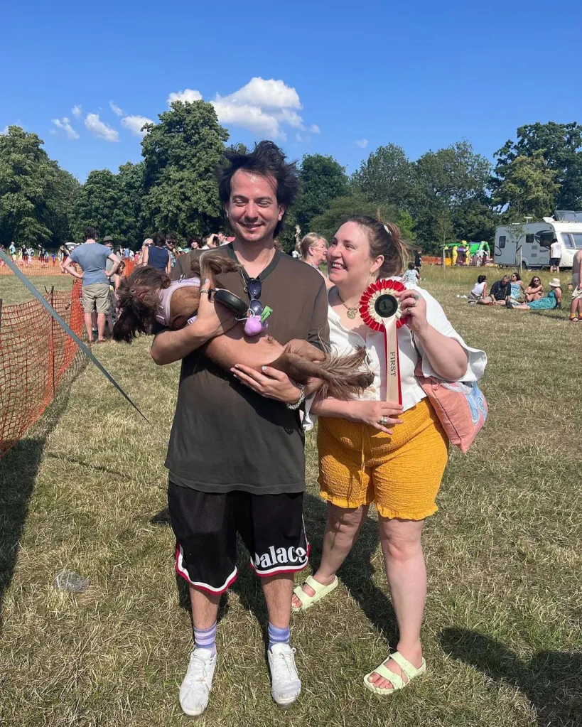 A man holds a dog while a woman next to him holds a