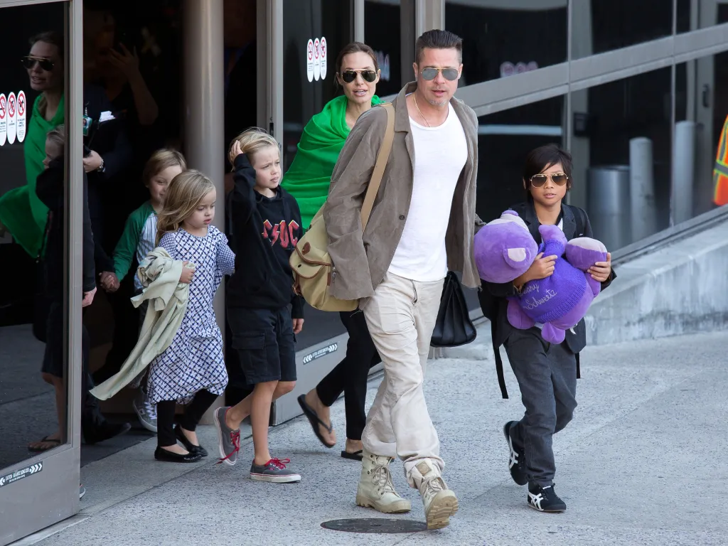 Brad Pitt, Angelina Jolie, and their children walk together at the Los Angeles International Airport.