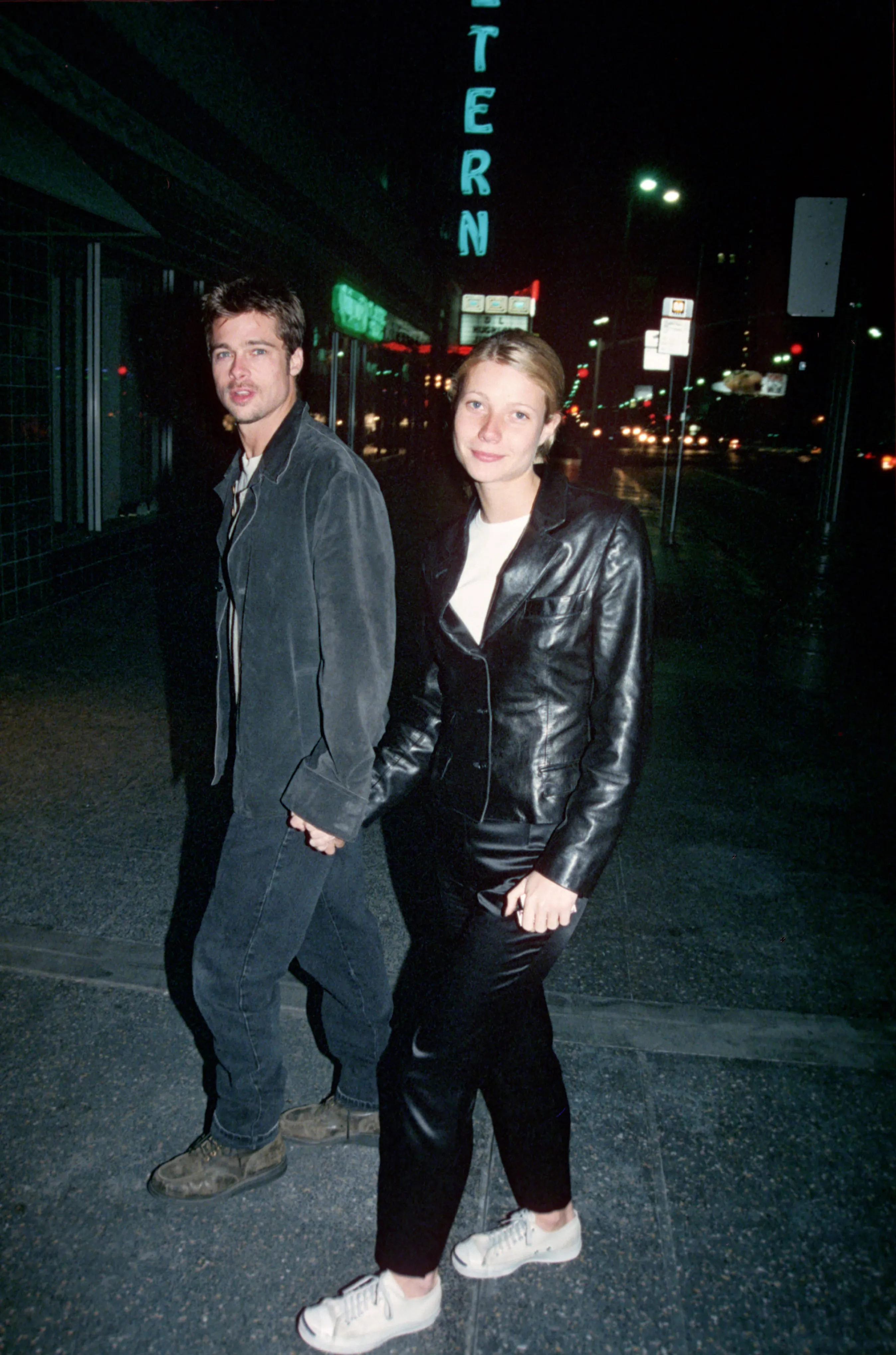 Brad Pitt and Gwyneth Paltrow holding hands at night.