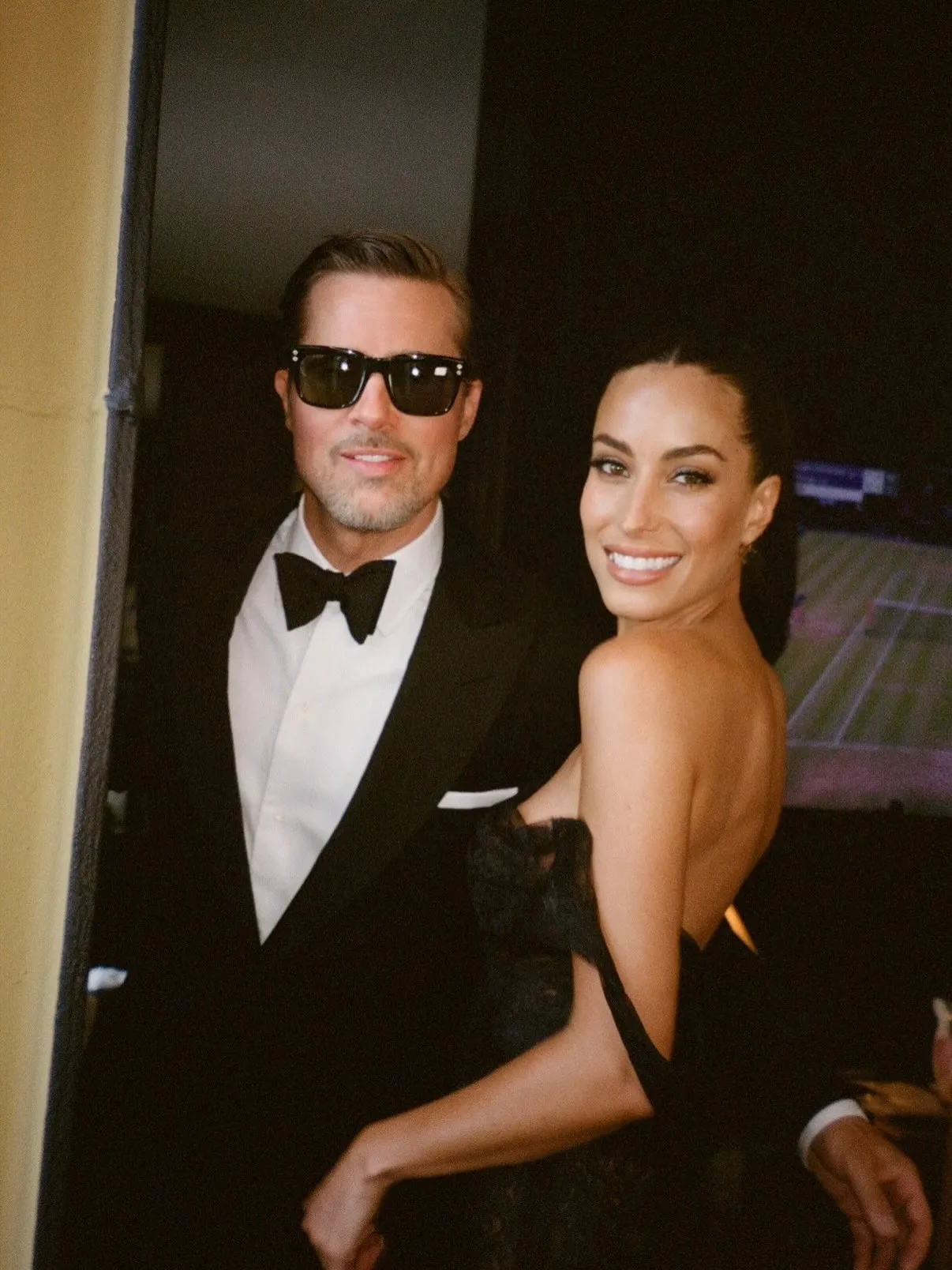 Brad Pitt in sunglasses and Ines de Ramon smiling in formal attire.