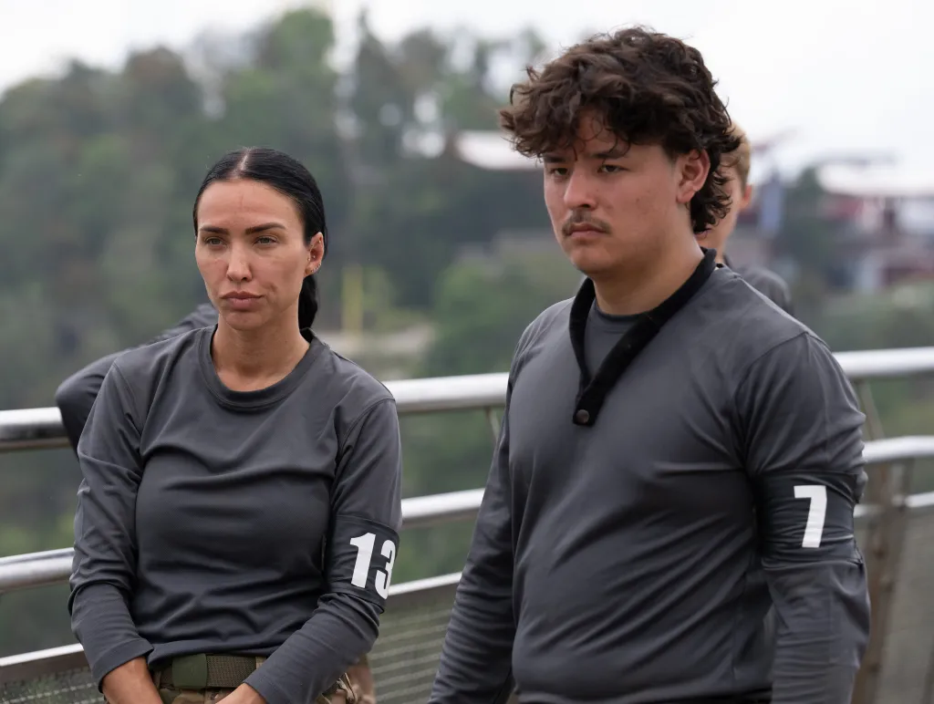Briana Tiesi and Collin Gosselin wearing gray shirts with armbands numbered 13 and 7 respectively, from the TV show 