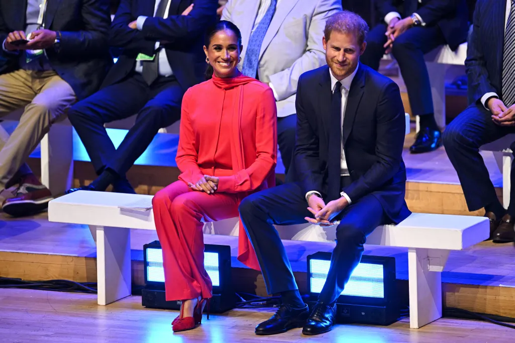 Meghan Markle and Prince Harry sitting on a white bench at the One Young World Summit.