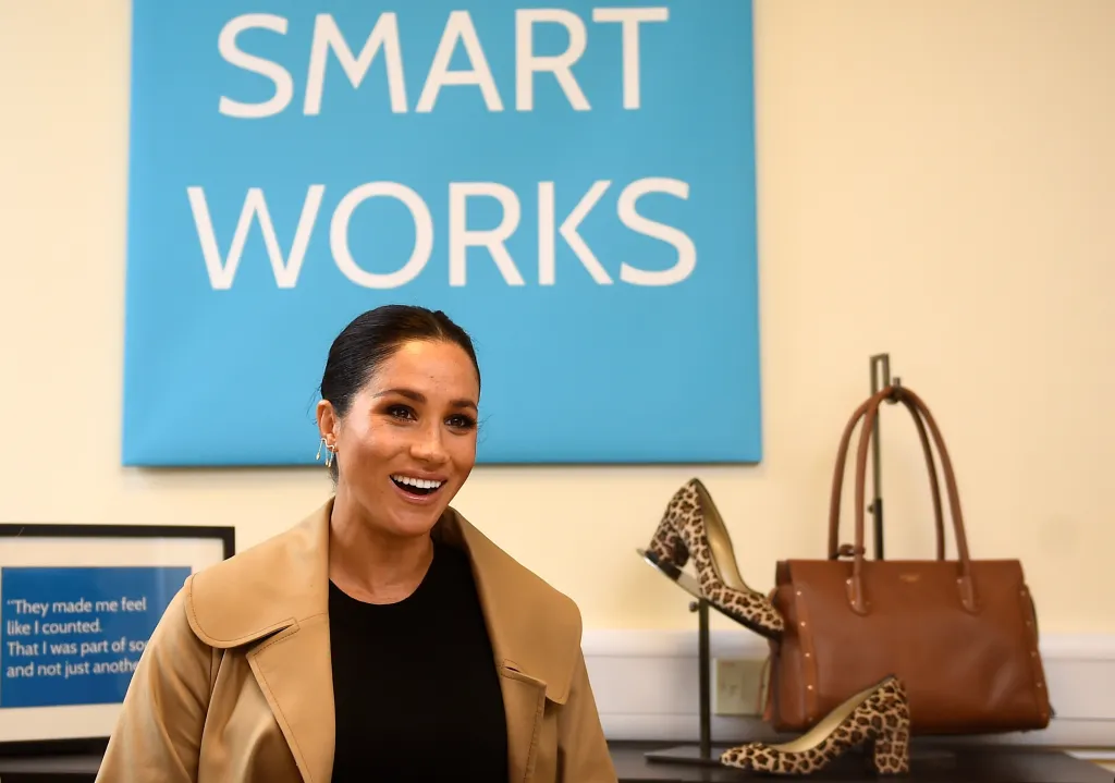 Meghan, Duchess of Sussex, smiling while visiting Smart Works, a charity providing clothing and coaching for unemployed women.