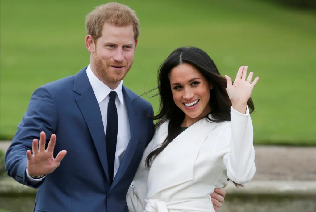 Prince Harry and Meghan Markle wave to the camera.