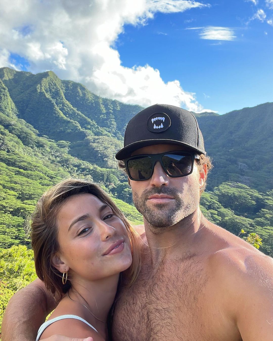 Brody Jenner and Tia Blanco pose for a selfie with a mountainous backdrop.