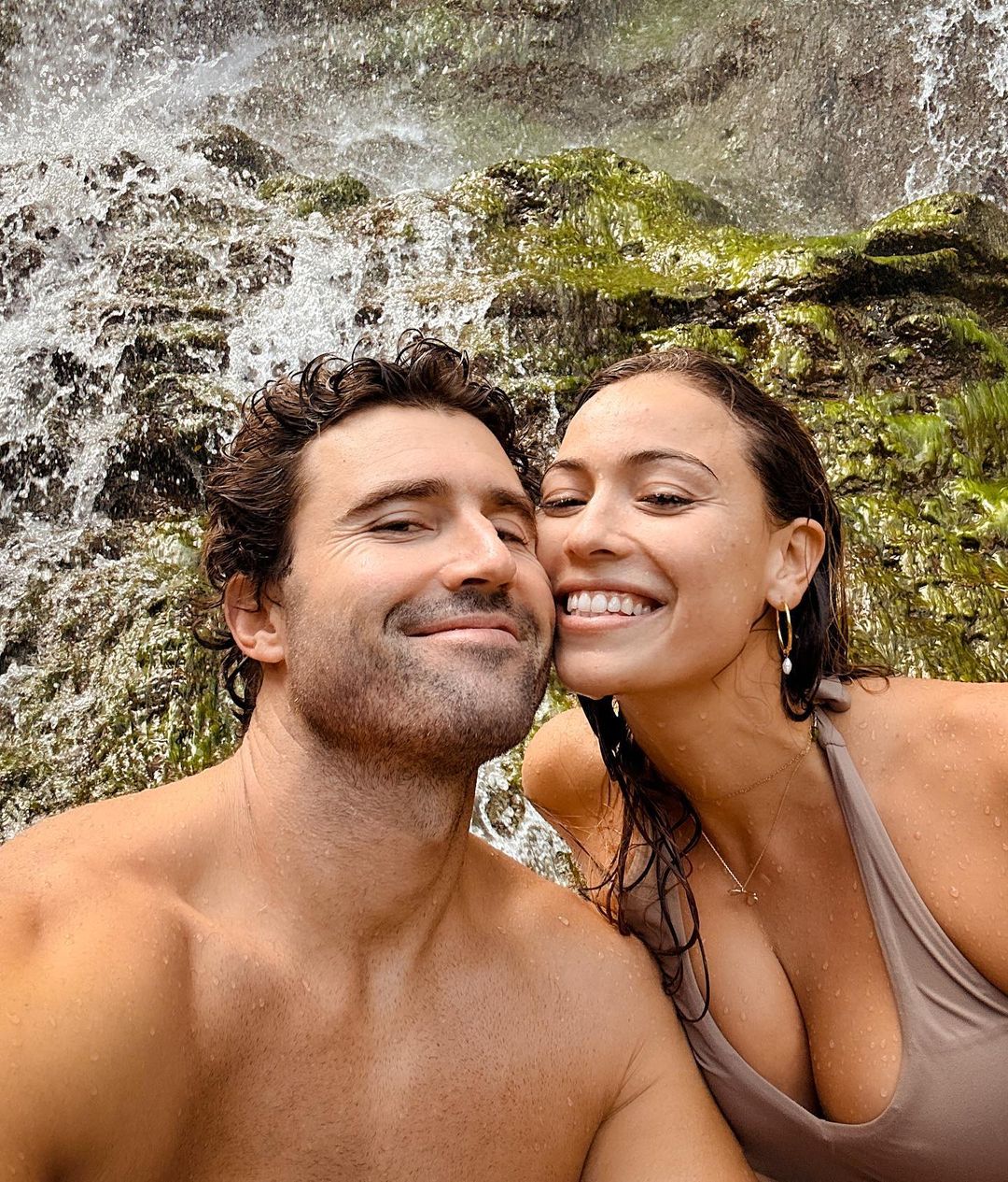 Brody Jenner and Tia Blanco posing in front of a waterfall.