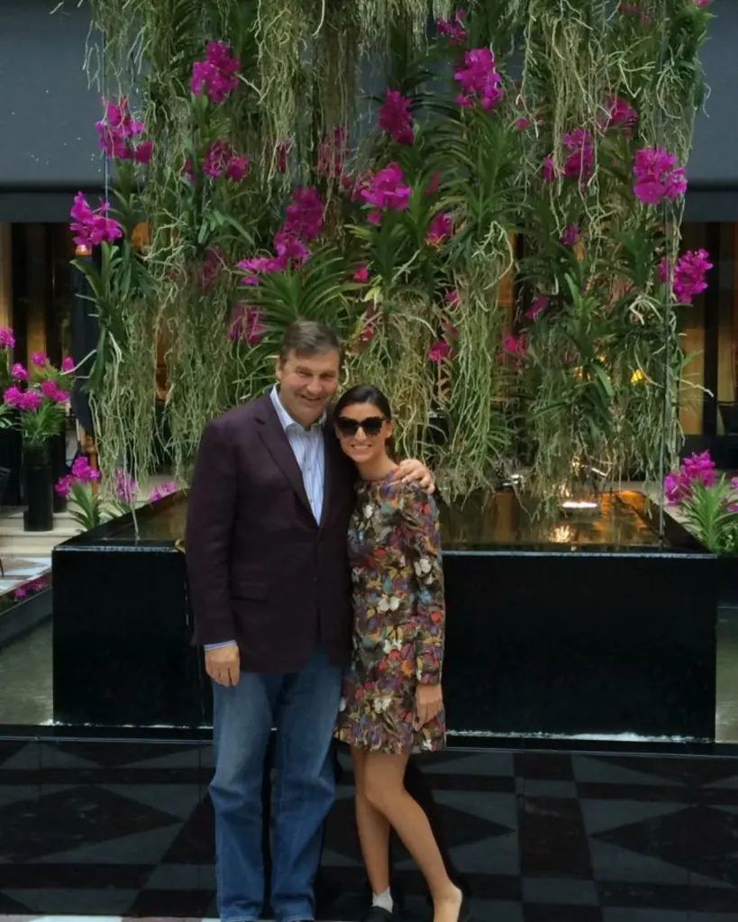 Bronwyn Newport and Todd Bradley standing together in front of a floral display.