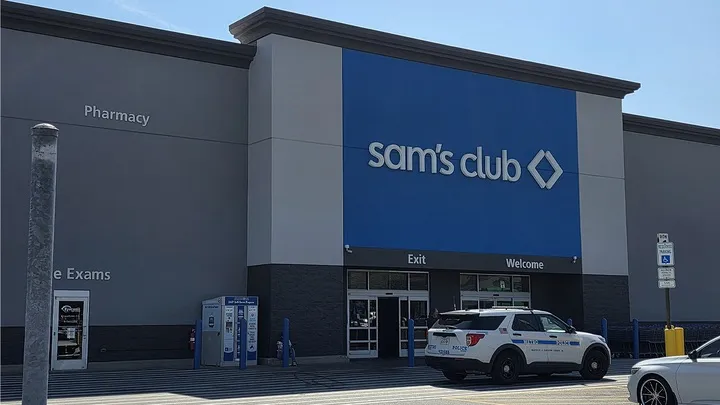 A police car parked outside a Sam's Club entrance.