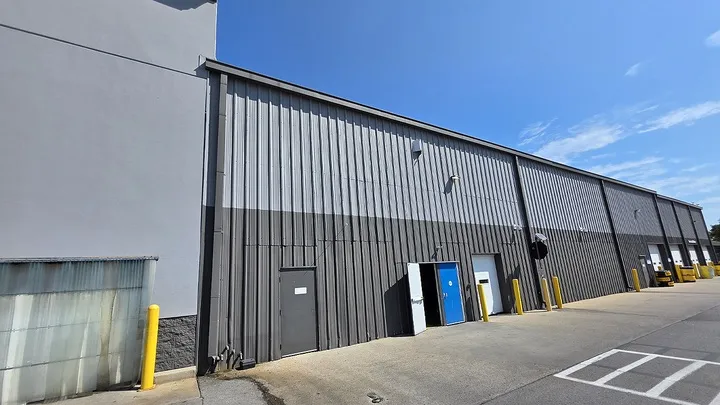 Exterior of a Sam's Club building with a bullet hole in the wall.