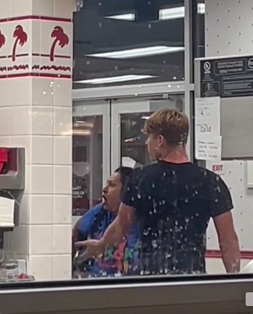 A person with a piece of broken wood is fought off by an individual with a spatula inside an In-N-Out store.