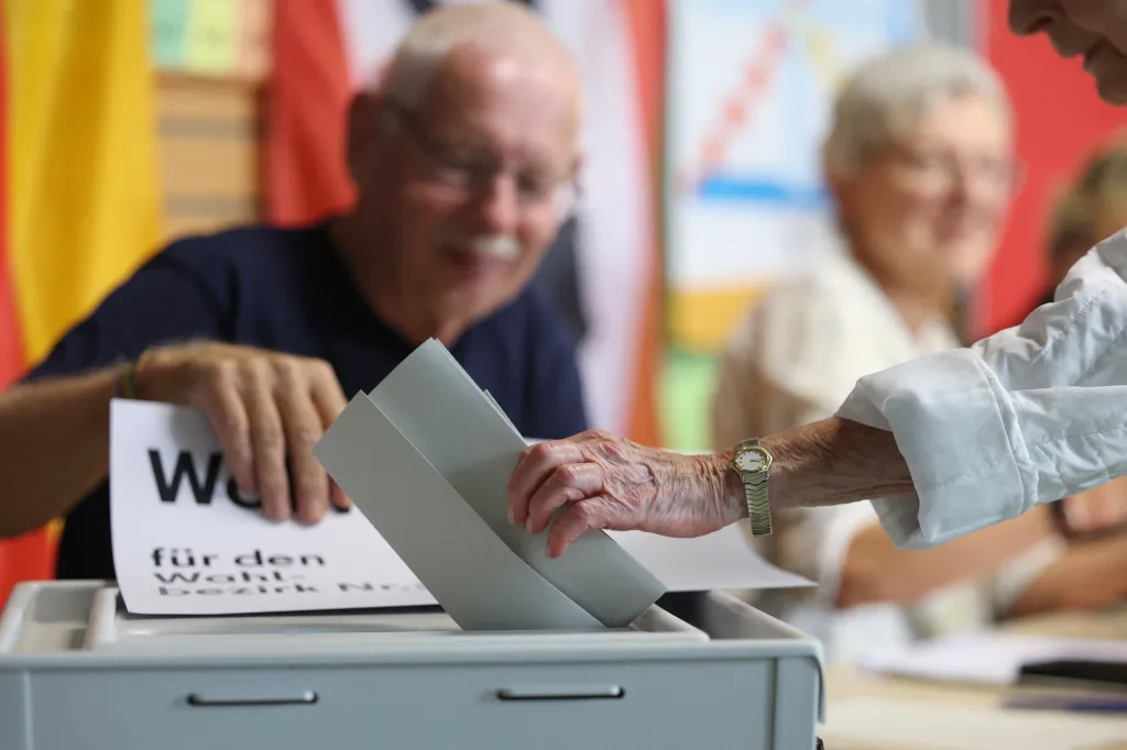 A person casts their ballot into a white box at a polling station in Berlin.