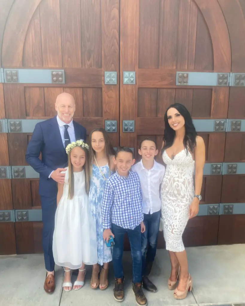 Carmella Garcia with her ex and four children, dressed up and smiling for a family photo.