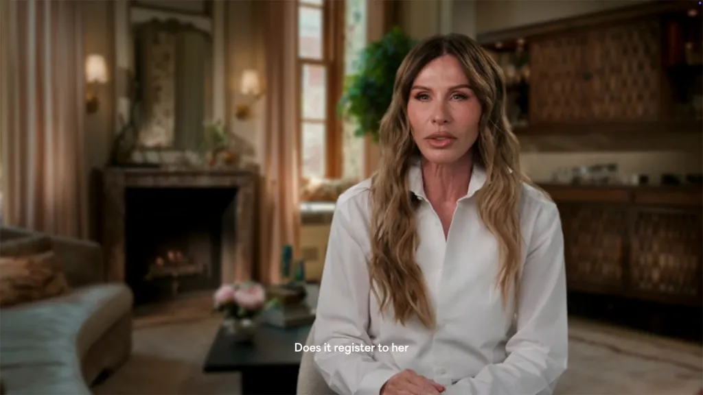 Carole Radziwill in a white shirt, seated in a room with a fireplace, as she discusses her RHONY co-star.