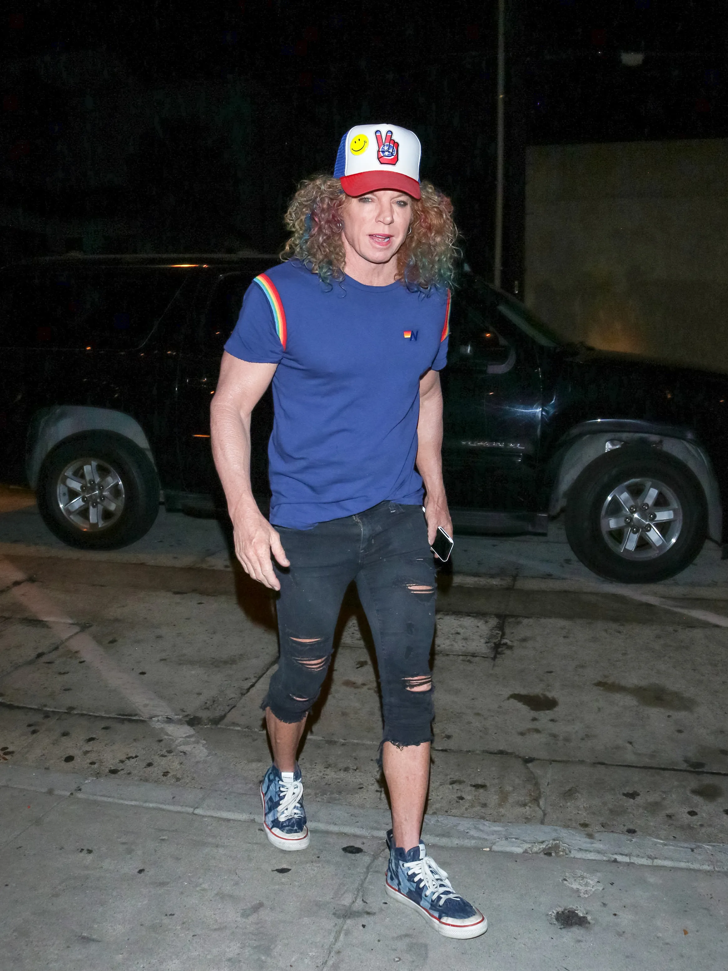 Carrot Top walking casually with a phone in hand.