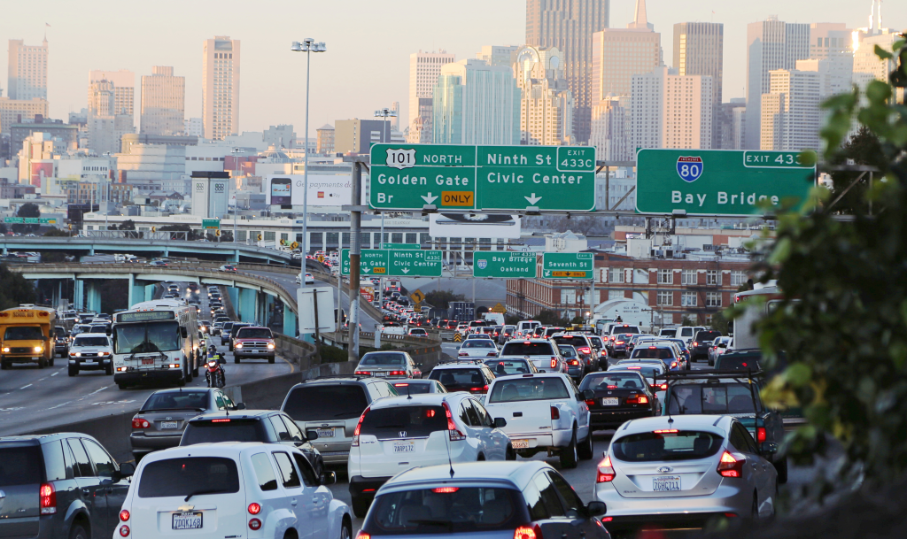 Traffic jam on a San Francisco highway with downtown skyscrapers in the background.