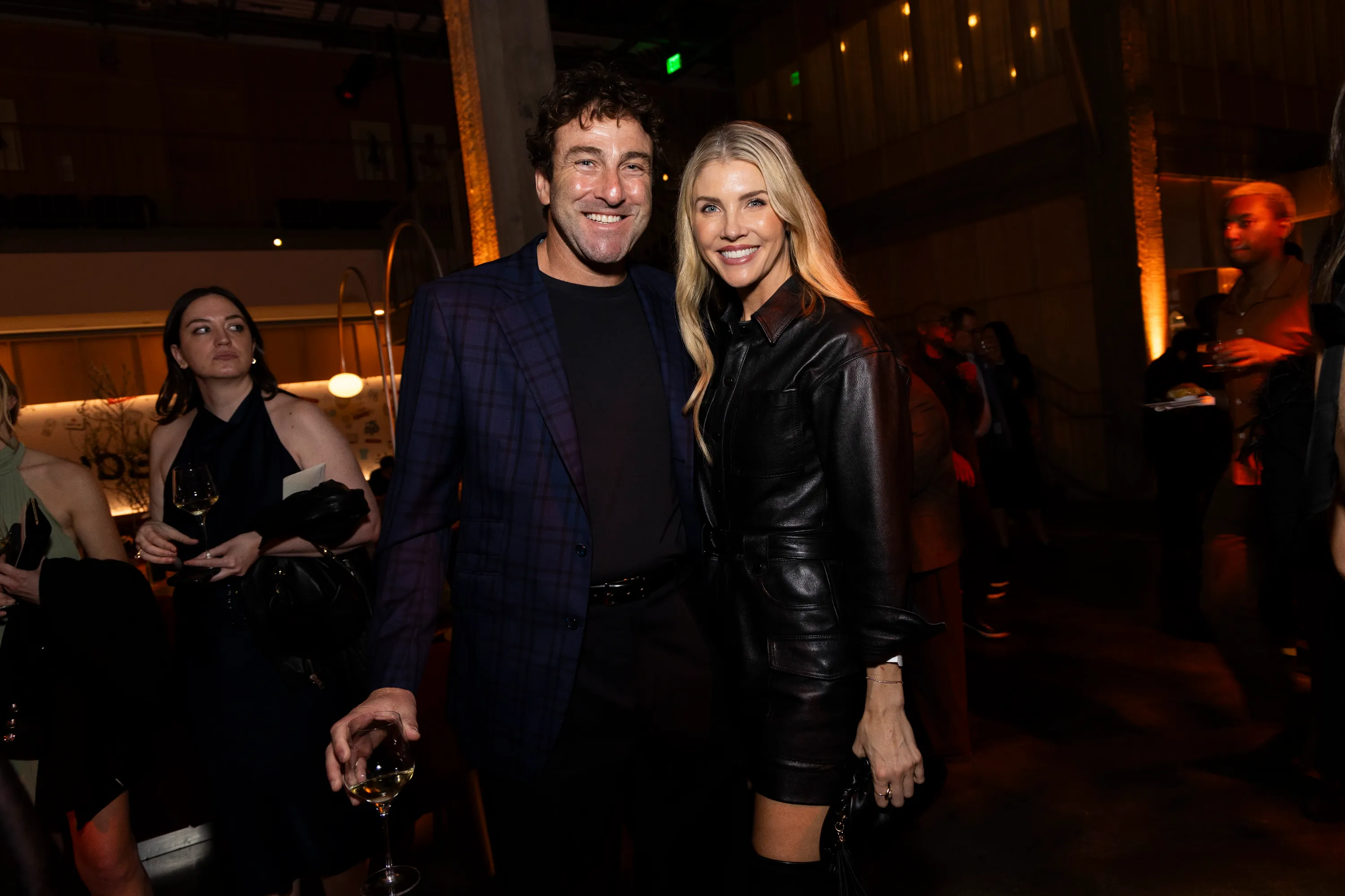 A man and a woman in formal attire smile at the camera.