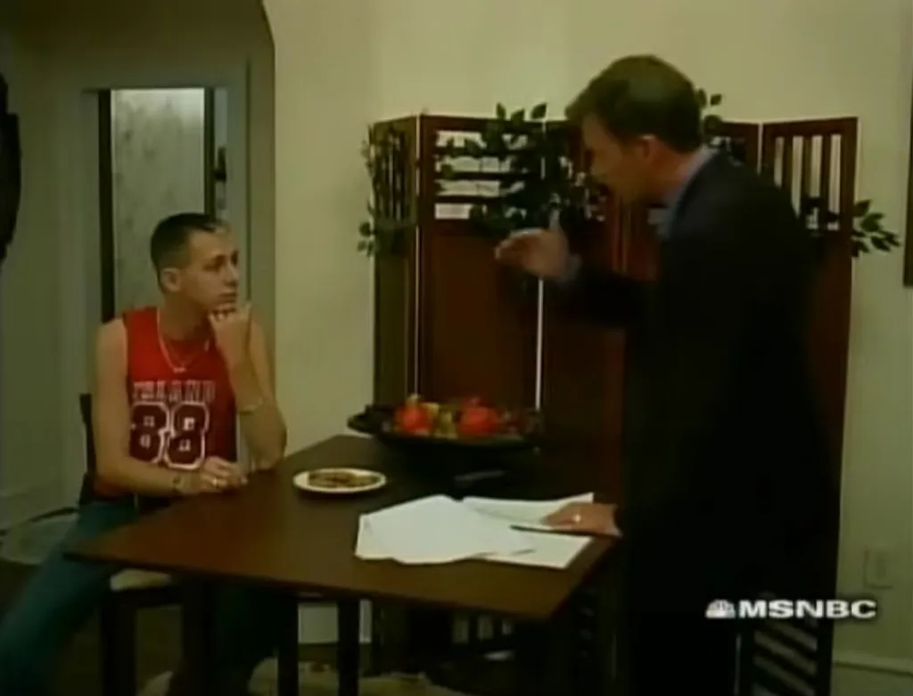 Chris Hansen confronting a man at a table.
