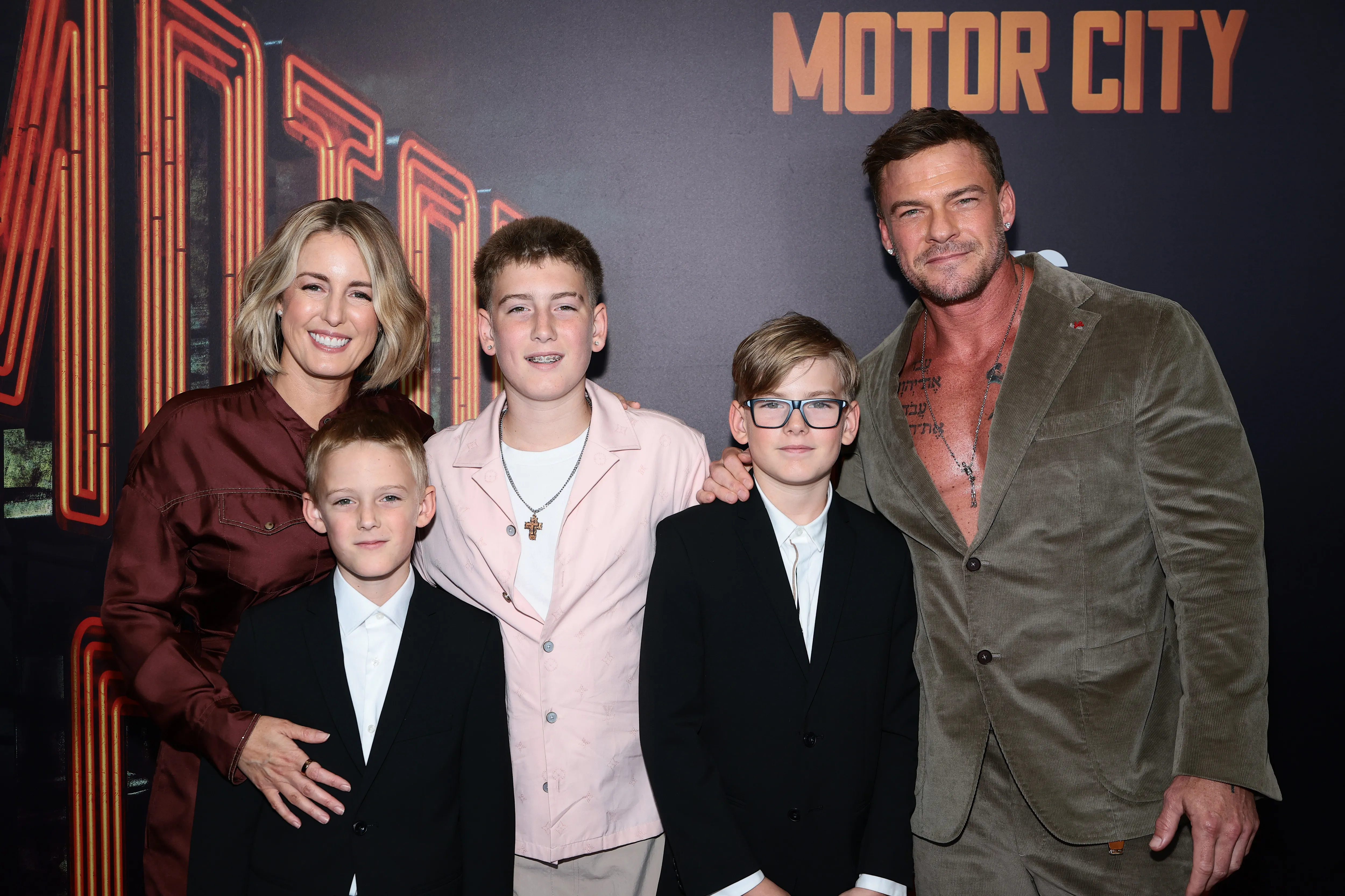 Catherine Ritchson and Alan Ritchson pose with their three children at the premiere of 
