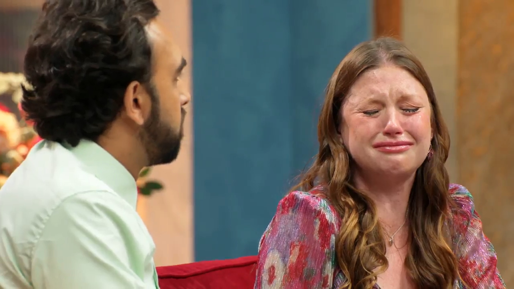Catie crying while a man looks at her.