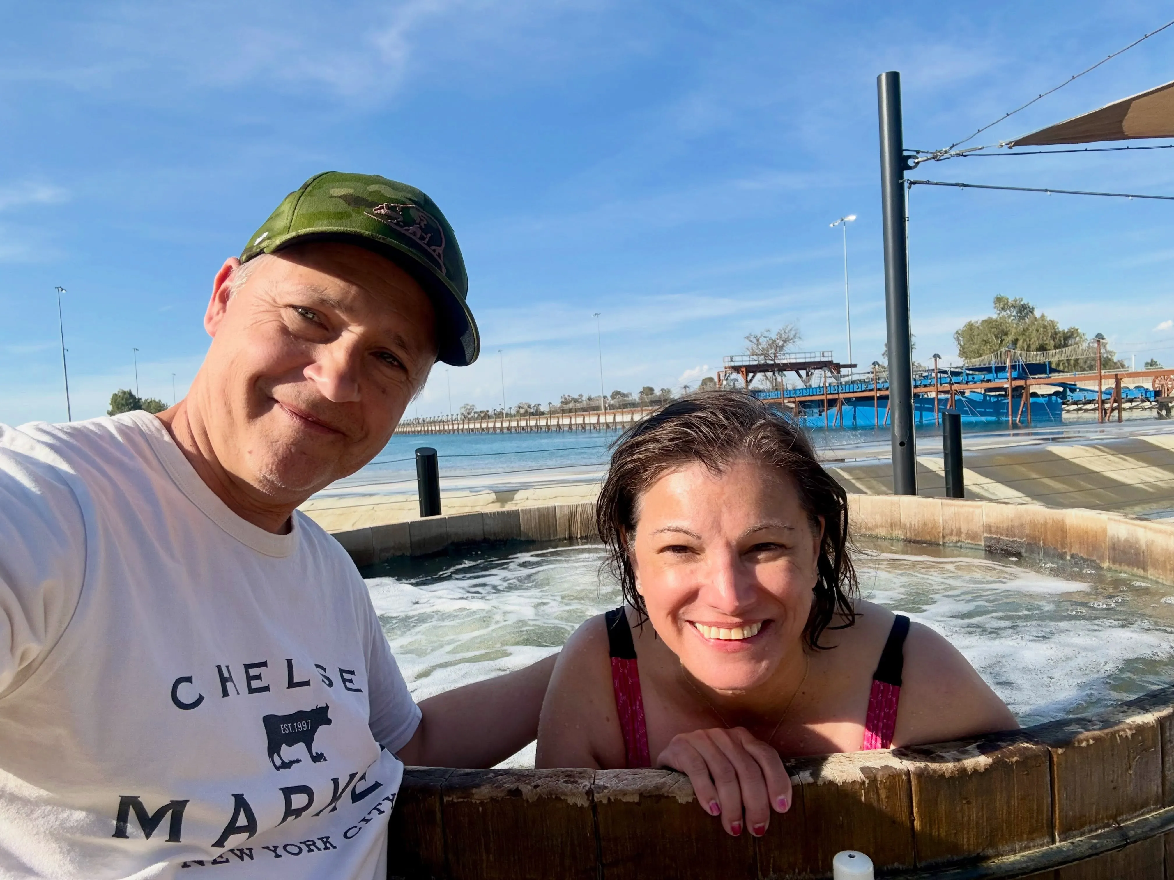 Chad Lowe and his wife Kim smiling together in a hot tub outdoors.
