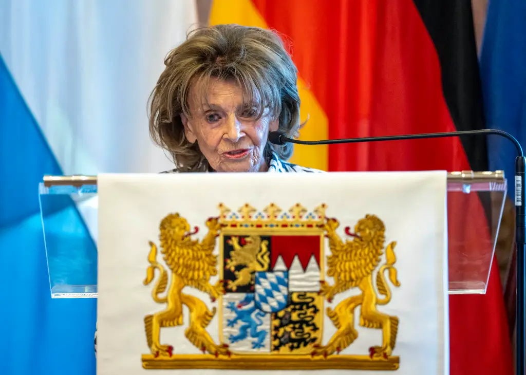 Charlotte Knobloch speaking at a podium with the Bavarian coat of arms.