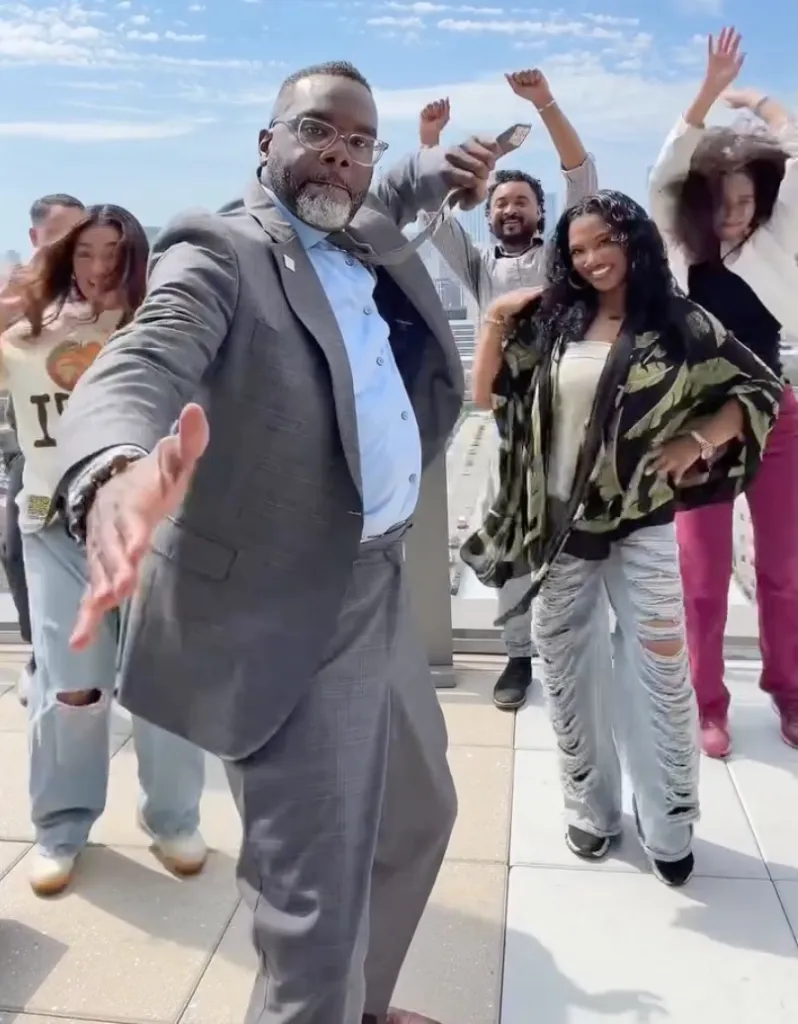 Chicago Mayor Brandon Johnson dancing on a rooftop with other people.