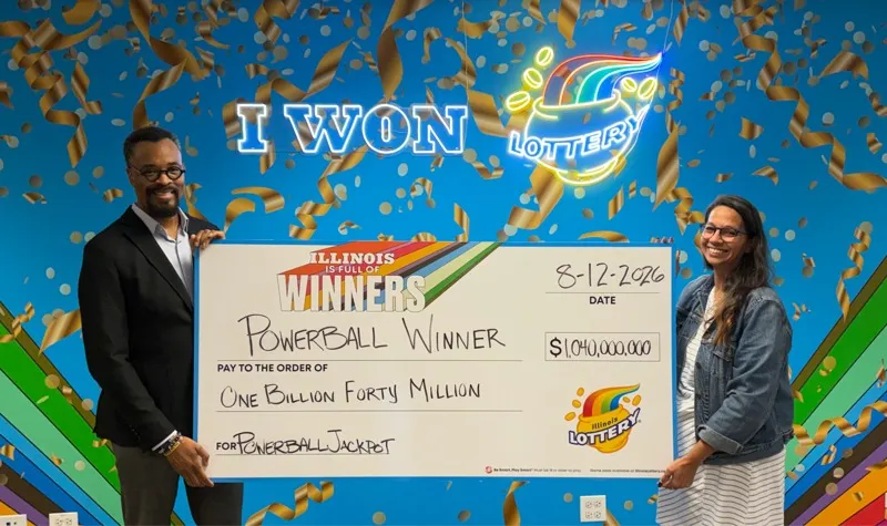 Illinois Lottery Director Harold Mays and Chicago Prize Center manager Amanda Crosas hold a check representing the $1.04 billion Powerball jackpot from the Aug. 12, 2026 drawing, in Chicago.