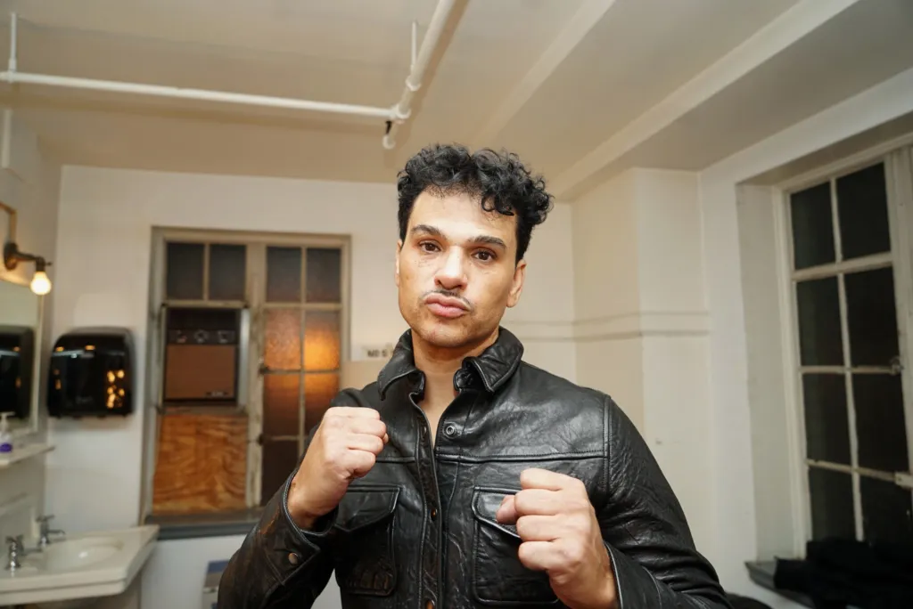 Chico Debarge in a black leather jacket backstage.