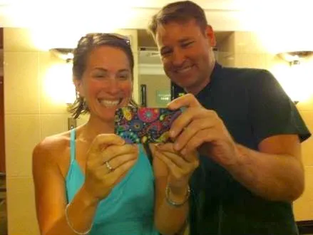 Christian Bradley Williams and his then-wife Amy Williams smile while holding up a phone with a colorful case.