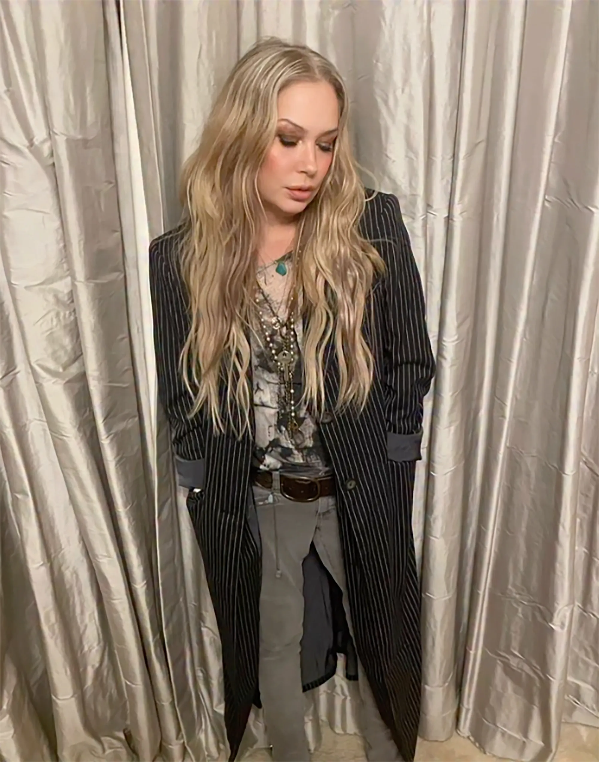 Christina Applegate in a long pinstripe coat and layered necklaces.