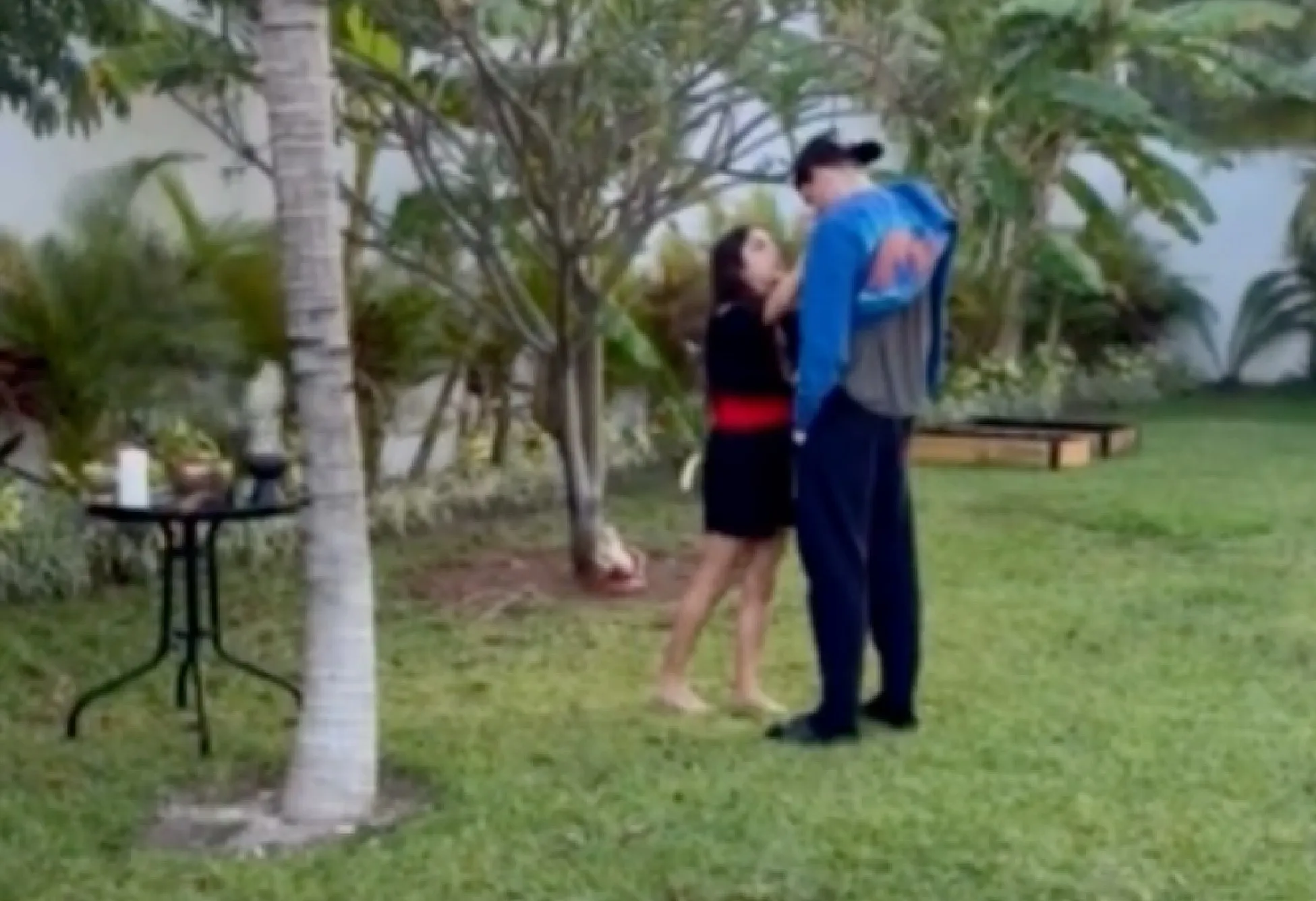 Presley Gerber standing in a grassy garden with a woman.