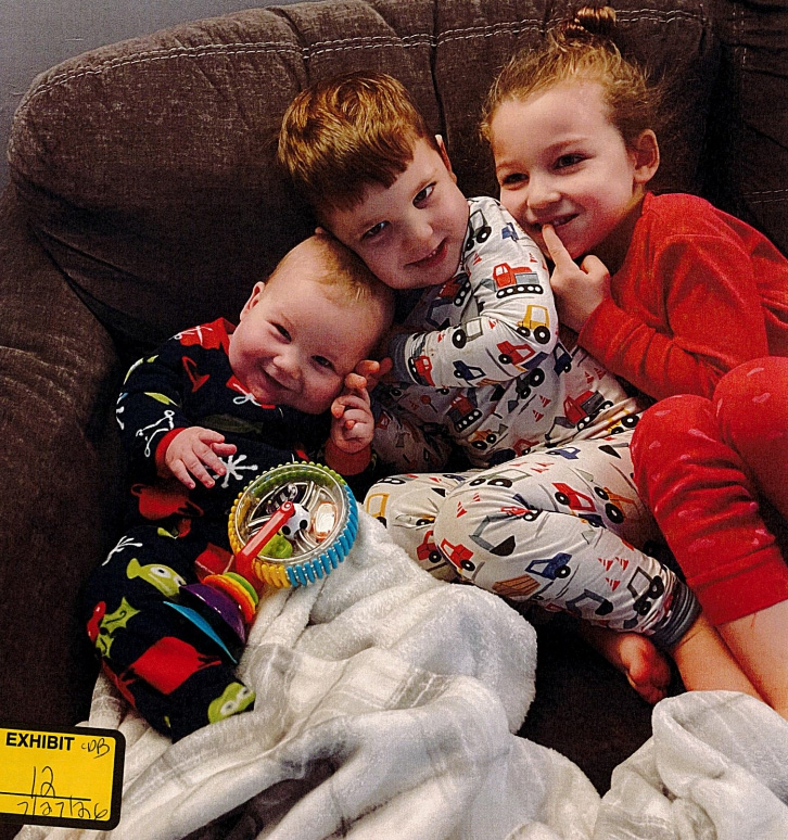 Callan, Dawson, and Cora Clancy snuggled together on a couch in undated photo from before their 2023 deaths