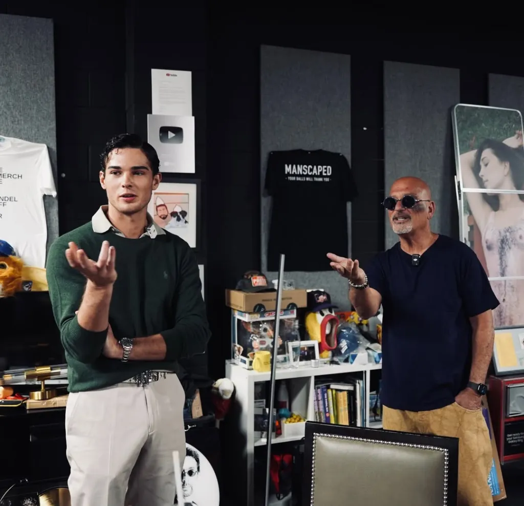 Two men gesturing as they converse in a room.