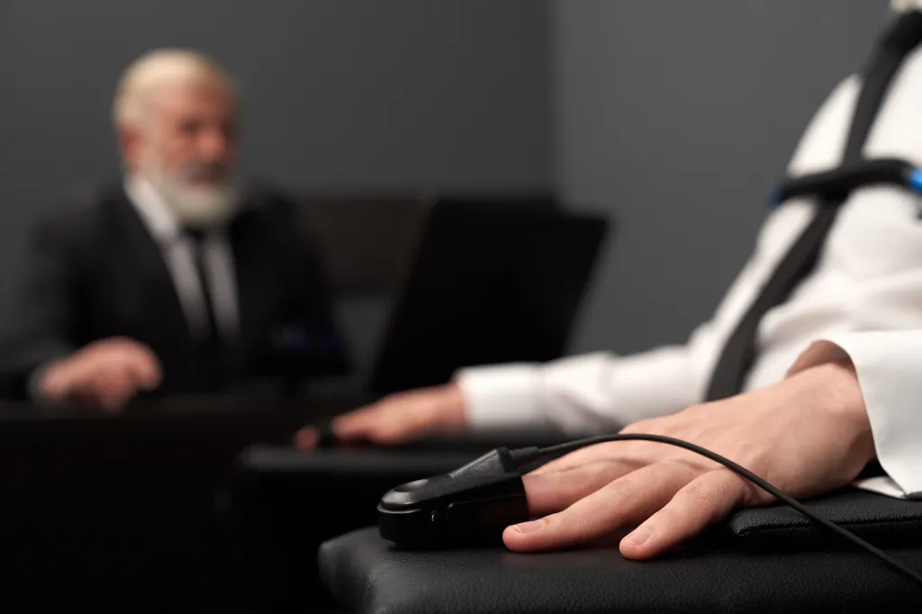 A pulse indicator attached to a man's finger during a lie detector test.