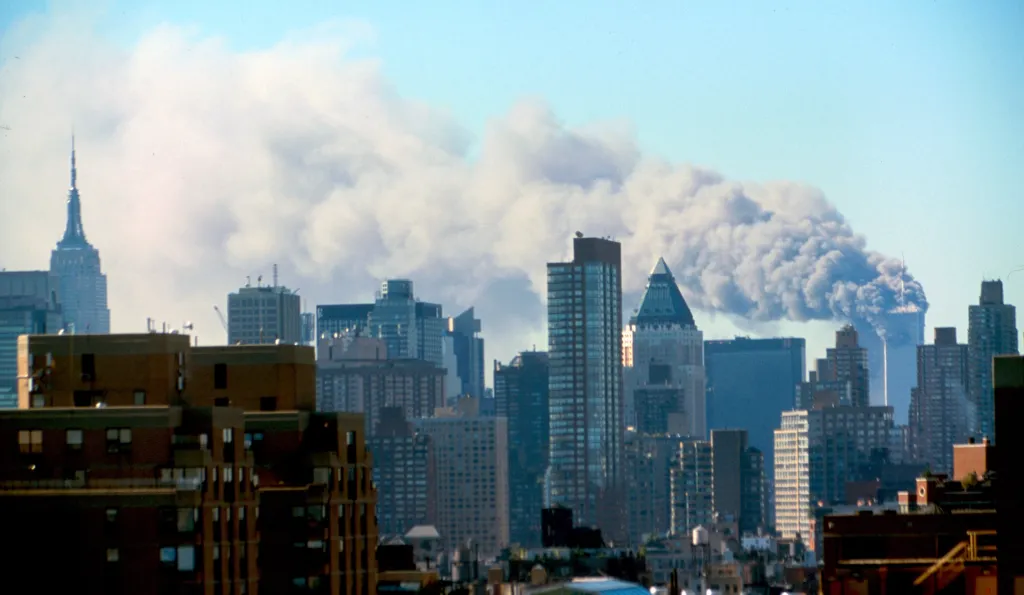Manhattan skyline with smoke plumes rising from the World Trade Center after the 9/11 terrorist attacks.