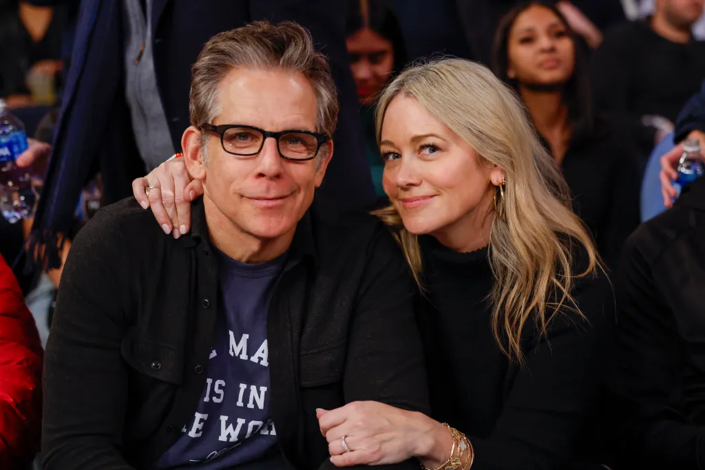 Ben Stiller and Christine Taylor pose for a photo at a basketball game.