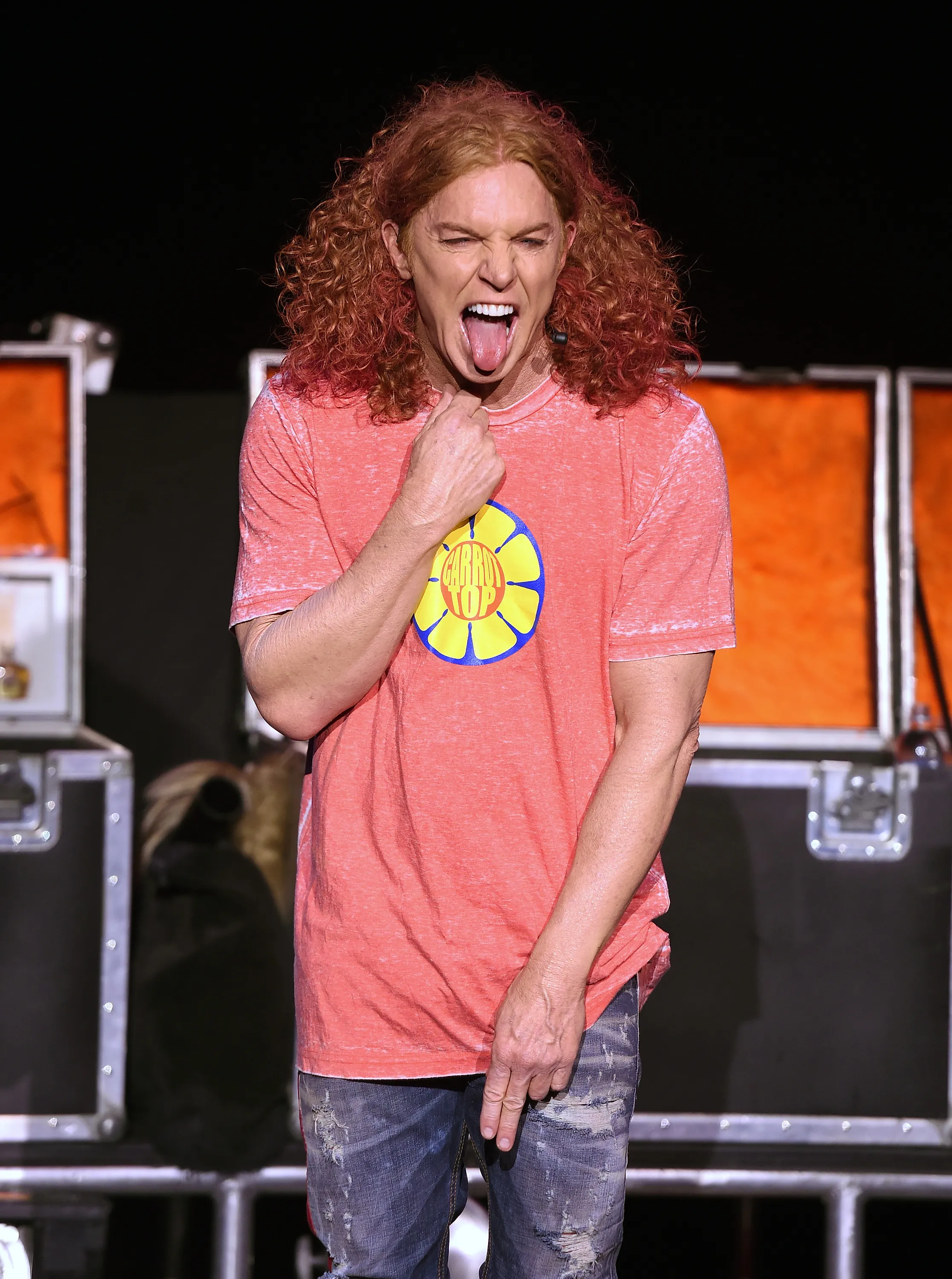 Comedian Carrot Top with curly red hair, sticking out his tongue.