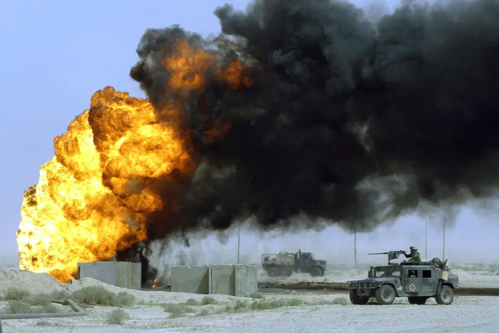 A convoy from the Marines 3rd Light Armoured Reconnaissance Battalion passes a burning oil well at the al-Ratka oilfield in southern Iraq.