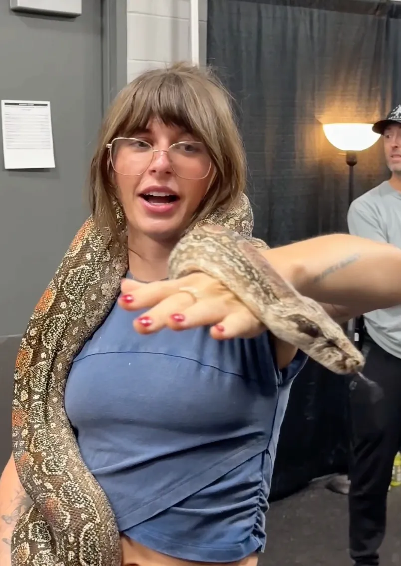 Country music star Ella Langley holds an Argentine Boa around her shoulders and arm.