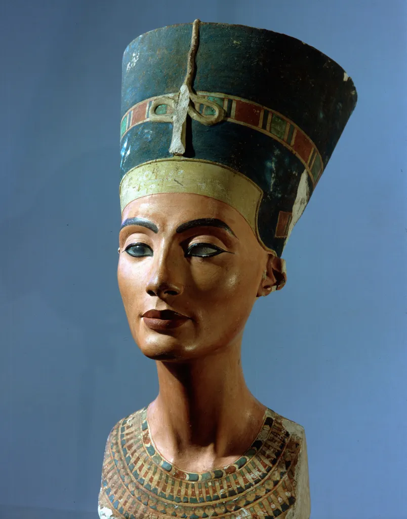 Sculpture of Queen Nefertiti wearing a flat-topped crown and an ornate collar.
