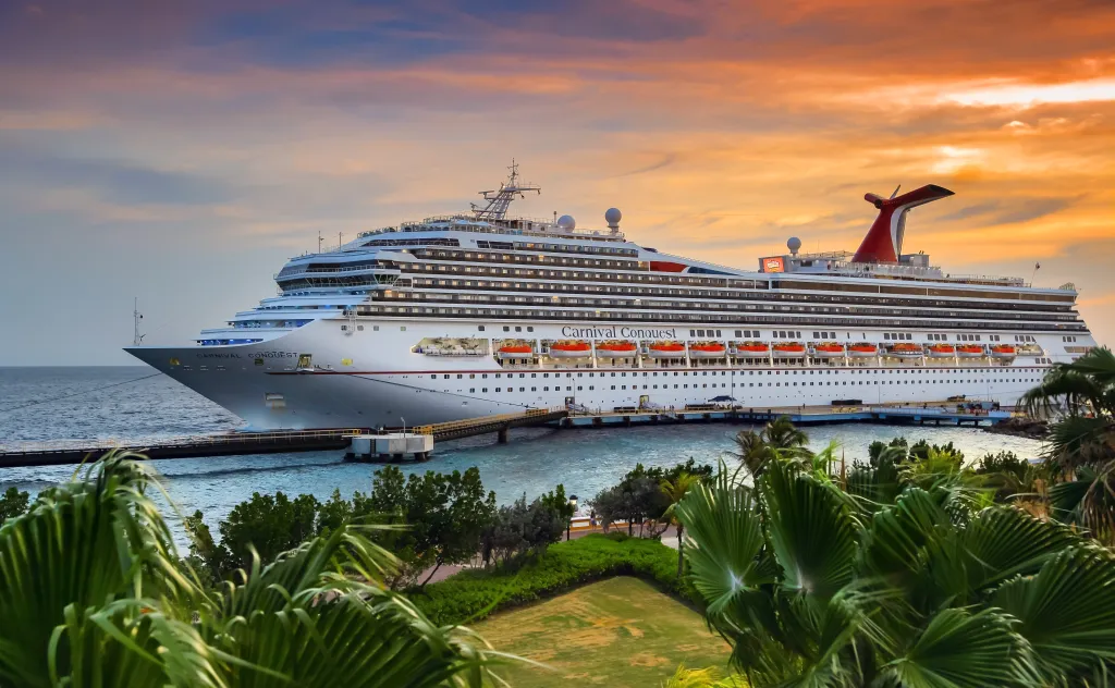 Cruise ship Carnival Conquest docked at port Willemstad at sunset.
