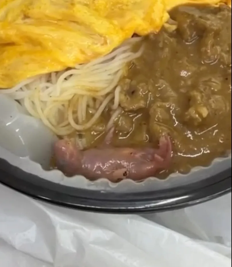 A newborn pink mouse in satay beef pasta with egg and noodles.