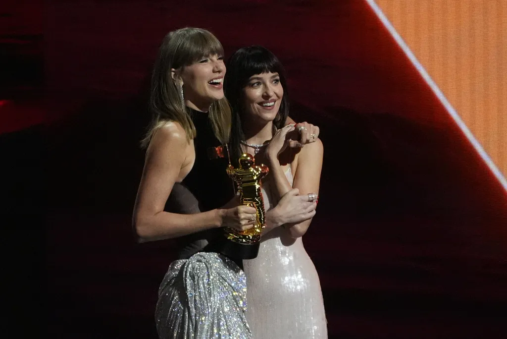 Dakota Johnson with Taylor Swift, who is holding the MTV VMA Artist Director Honors award.